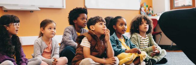 Students paying attention Group of students sitting on the floor of the classroom paying attention