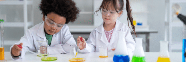 Elementary science students are conducting experiments with beakers and colors