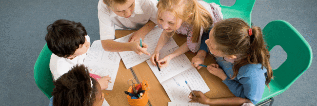 Students-working Students sitting around a table working on a Jigsaw Strategy Lesson Plan