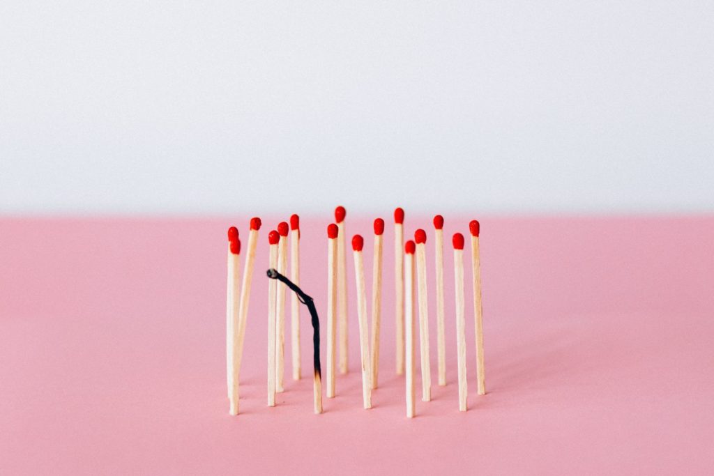 Matches on the pink background with one match burnt out