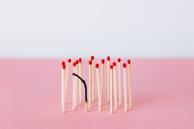 Matches on the pink background with one match burnt out