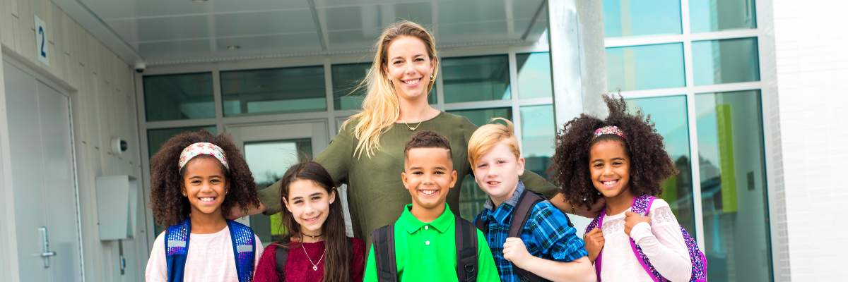 Student-with-teachers-1 Class smiling together with teacher