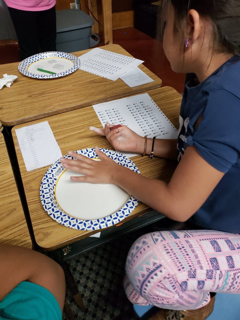 Kristin Wolfgang’s students making cuneiform letters in air drying clay.