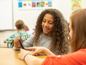 Girls using Studies Weekly Online on tablet