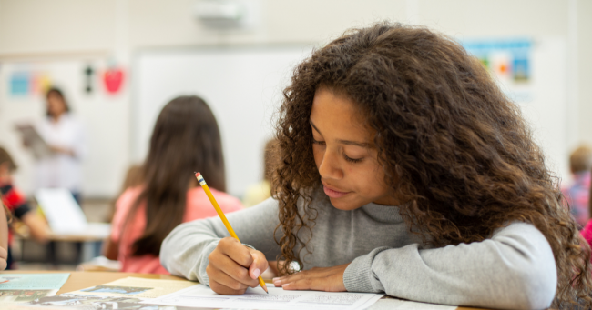 Student writing on studies weekly publication Studies Weekly Student Working