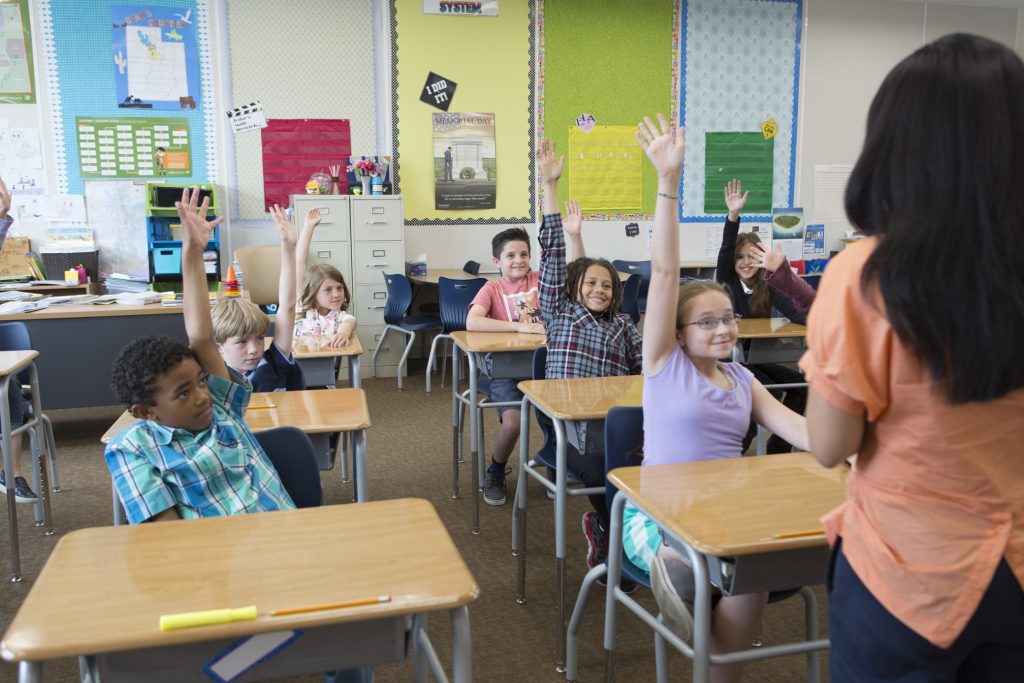 Students raising hands Students raising hands in the classroom