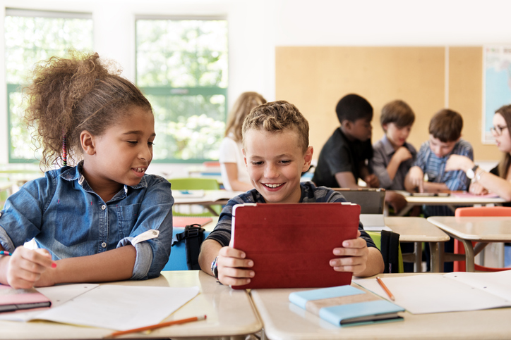 School kids in class using a digital tablet Active participation in class