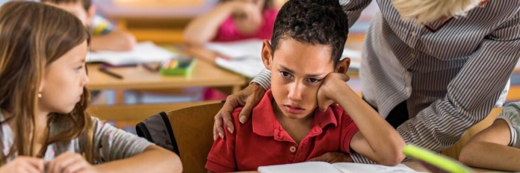 Struggling-Student-October-2025 Teacher helping elementary student deal with negative emotions