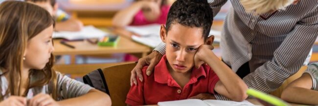 Teacher helping elementary student deal with negative emotions
