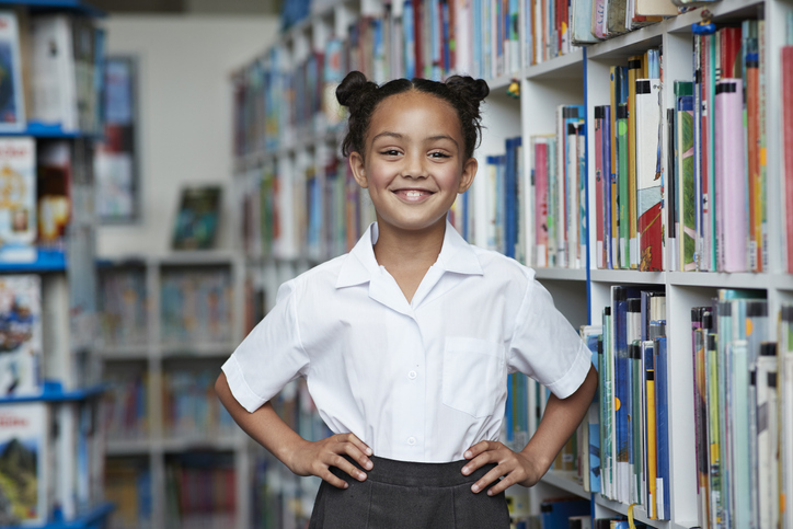 Portrait of cute schoolgirl at the library Elementary student who feels confident
