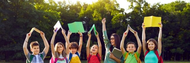 Teacher and students holding up books
