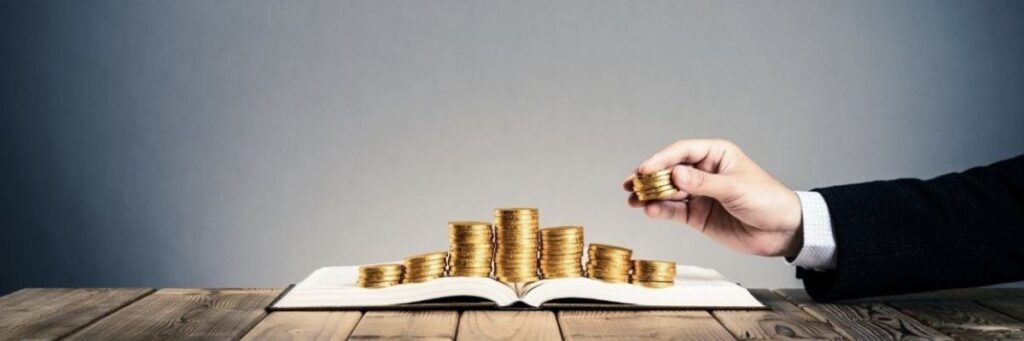 Spending Adoption Dollars - October 2025 Coins stacked on an open book.