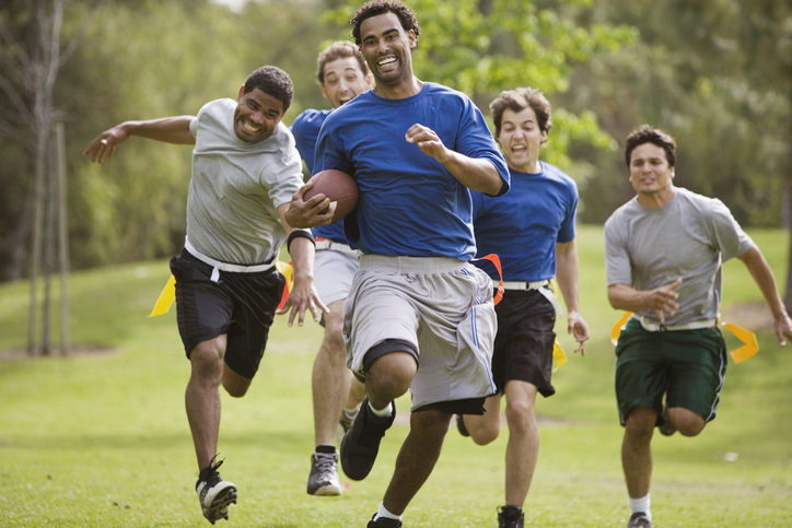 Men playing flag football together Men playing flag football to have work life balance