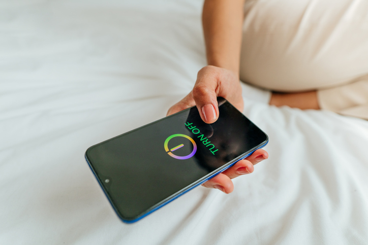 Close up of female hand turning off the smartphone Woman turning phone off to have work life balance