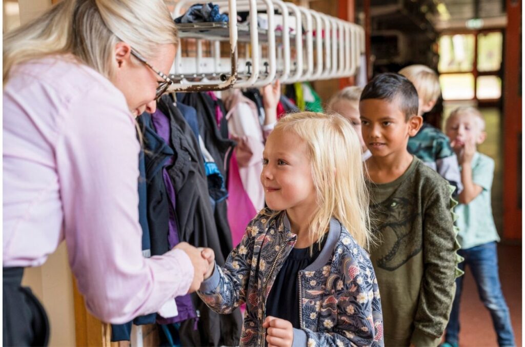 Teacher greeting children Teacher connects to students by greeting them.