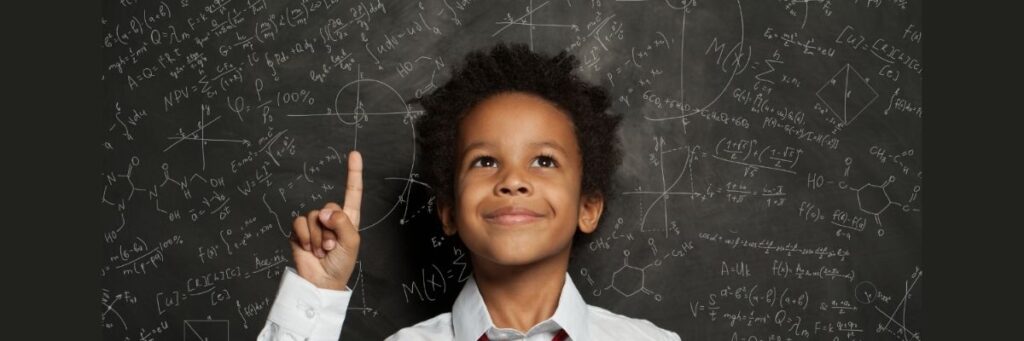 Student-with-Science-Chalkboard-November-2025 Inquiry-science child standing in front of the science background