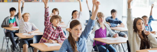 Classroom Full of Students Students raising hands in the classroom