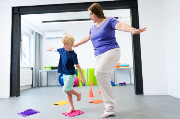 Student and teacher balancing on one foot