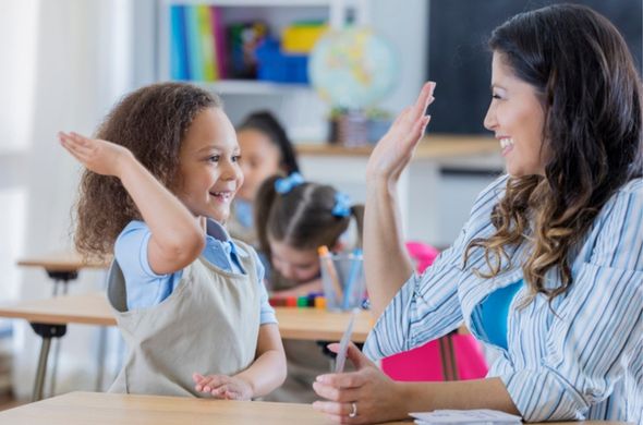 Teacher-gives-student-a-high-five Teacher supporting children
