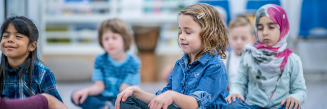 Elementary students doing breathing exercises together