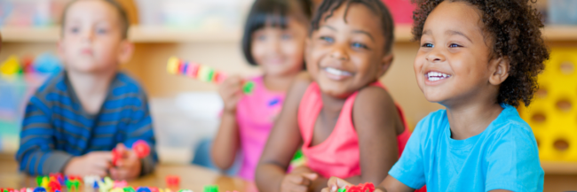 Children smiling and playing games to enhance their learning