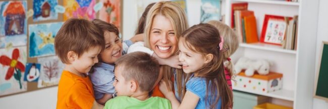 Teacher and students A teacher and young students in a group hug