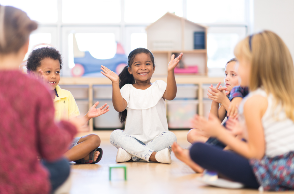 Kids sitting in a circle clapping Kids sitting in a circle doing actions to learn social studies concepts with music