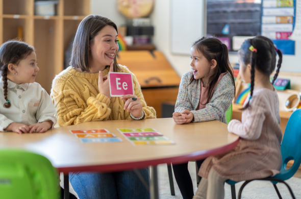 Learning letter sounds Teacher holding letter card to teach phonics to model the science of reading