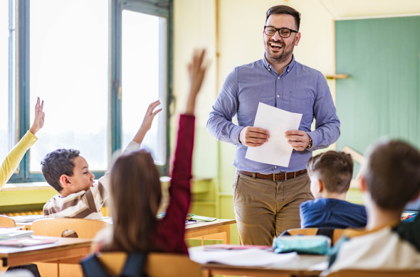 Positive teacher New teacher at the front of the classroom asking student questions