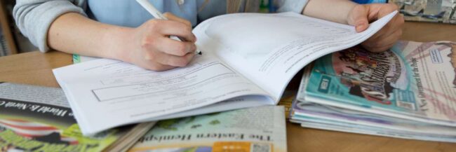 Teacher writing in Teacher Edition at desk