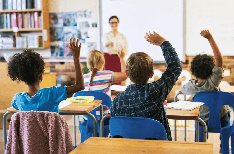 Classroom children raising hands waiting to be called on