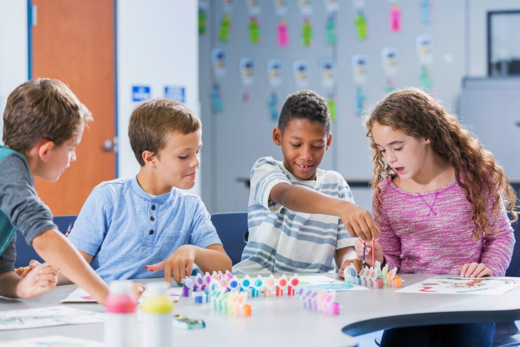 Kids working on art projects with paints