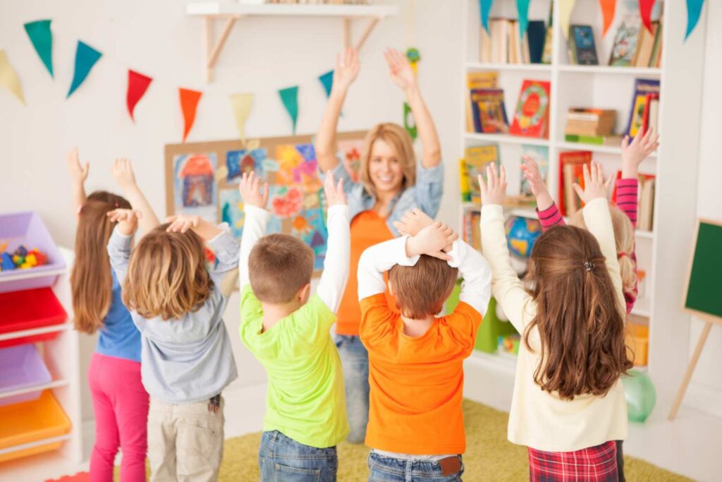 Children in a classroom dancing and stretching