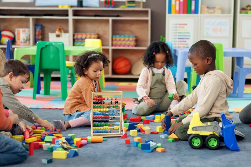 Children in a preschool playing with blocks and cars