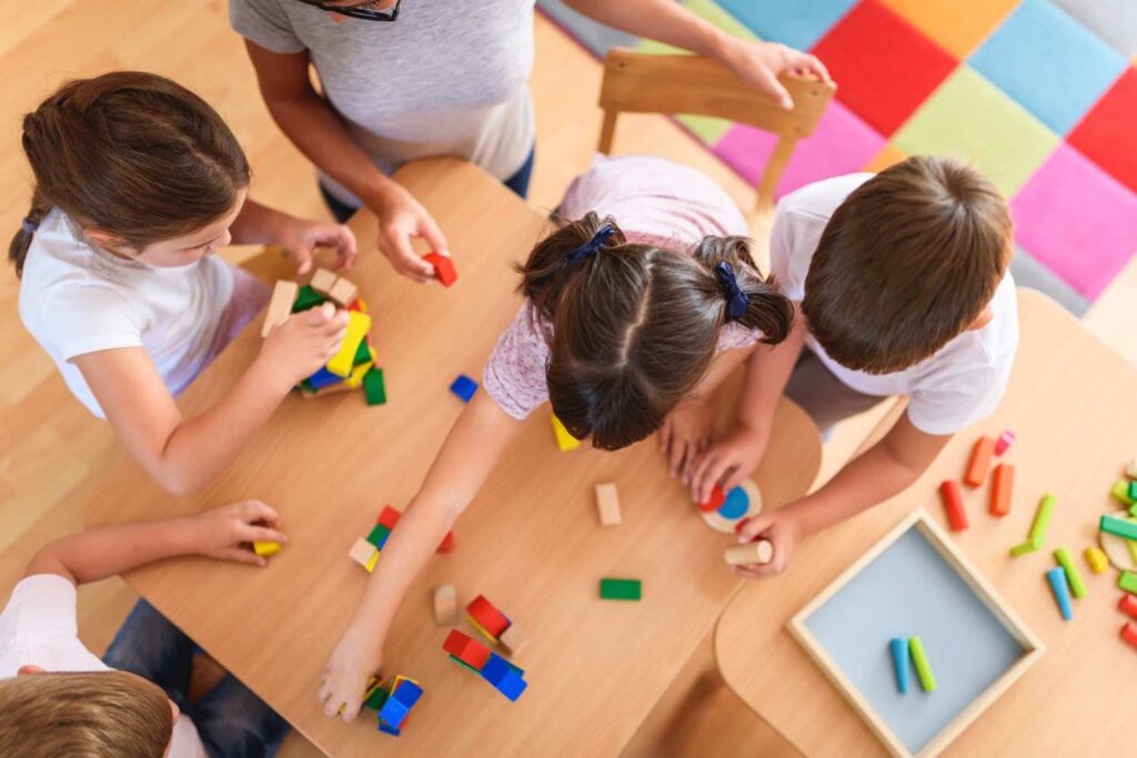Kids playing at a table with building blocks