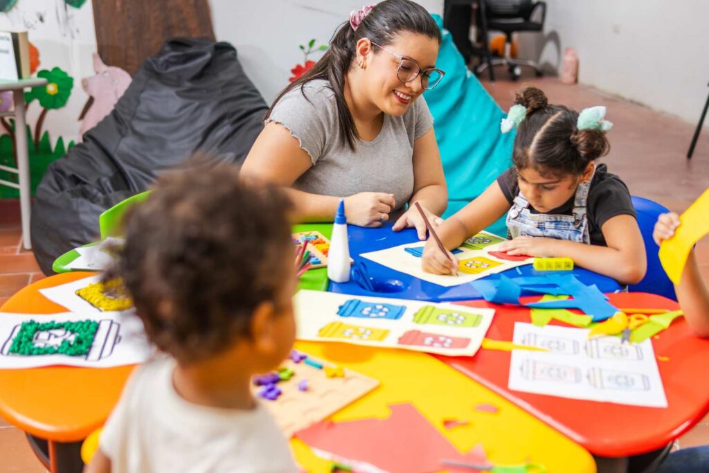 Preschool children sitting around a table coloring