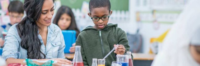 Science teacher helping a student