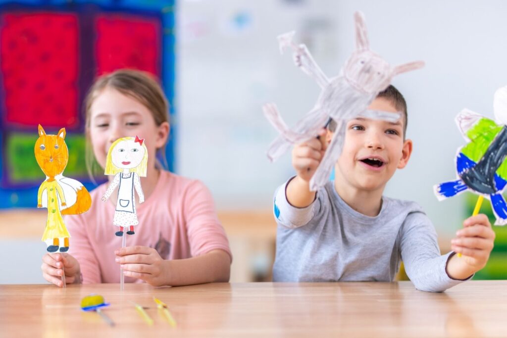 Kids playing with paper puppets to learn with play-based activities