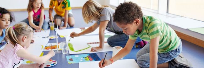 Young students sitting together and painting