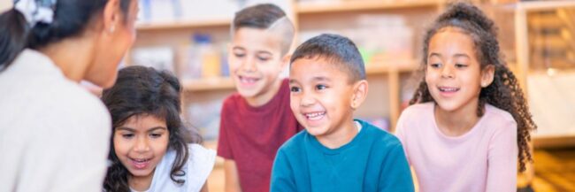 Happy students who are emergent bilinguals listening to their teacher