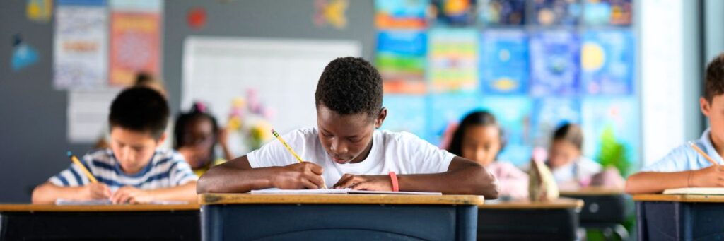 Students testing Elementary students sitting at their desks taking a test