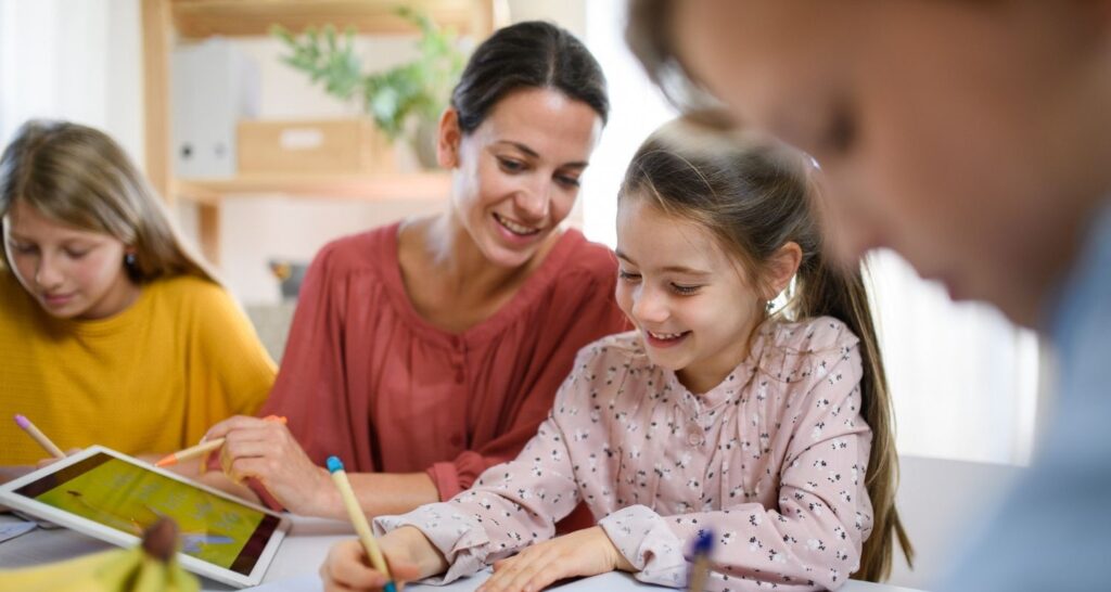 Teacher Helper Parent helping student in elementary classroom