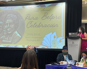 Photo taken of a slide presentation at an awards show that reads "Pura Belpré Celebración."
