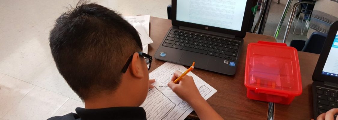 Student filling out graphic organizer Studies Weekly Spotlight